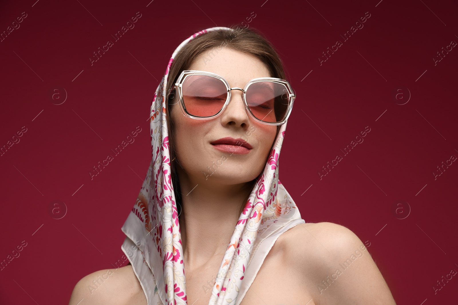 Fashionable portrait of beautiful woman in stylish outfit on dark red background Photo of Fashionable portrait of beautiful woman in stylish outfit on dark red background