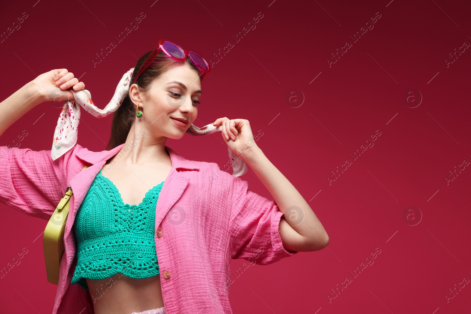 Fashionable portrait of beautiful woman in stylish outfit on dark red background. Space for text Photo of Fashionable portrait of beautiful woman in stylish outfit on dark red background. Space for text