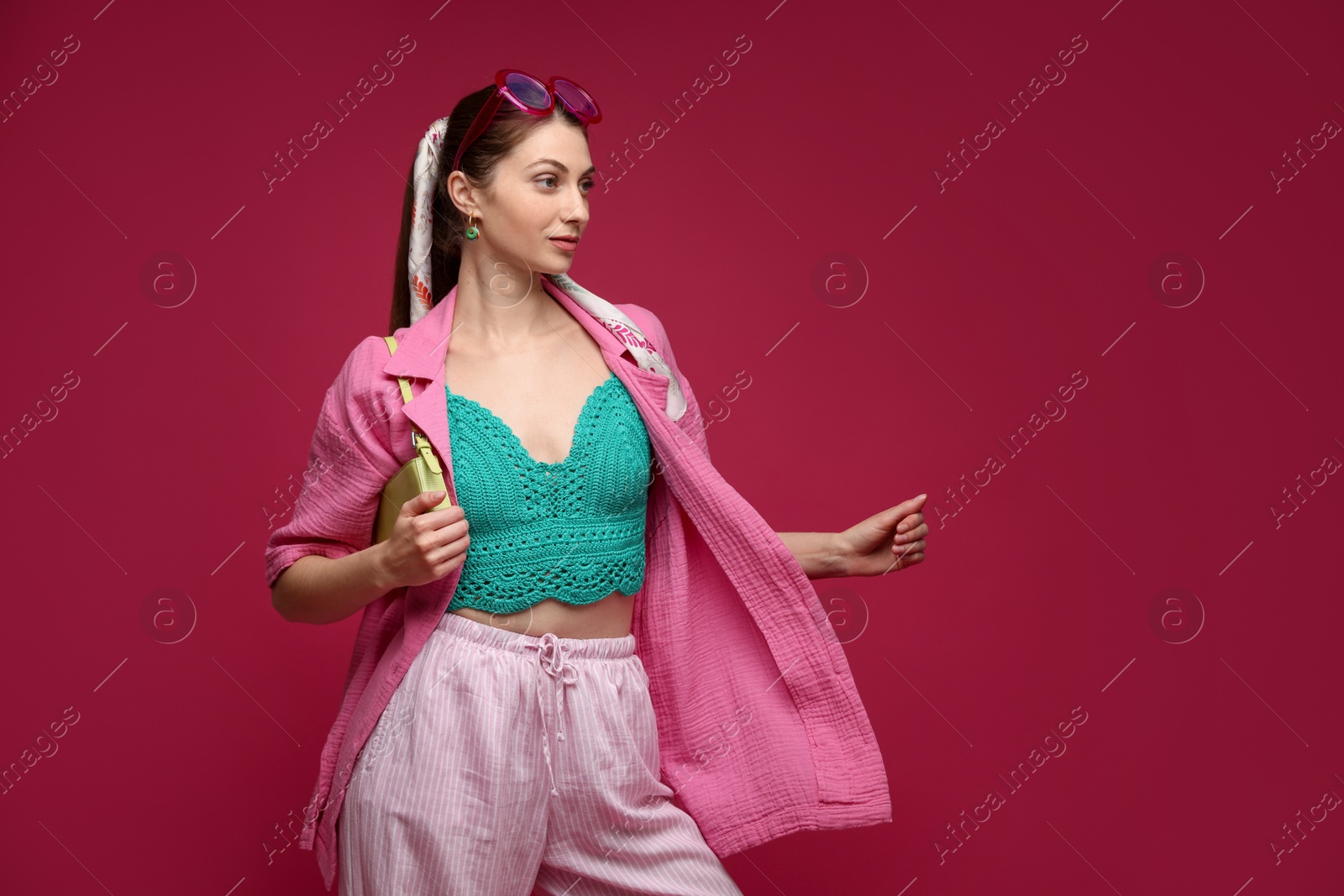 Fashionable portrait of beautiful woman in stylish outfit on dark red background. Space for text Photo of Fashionable portrait of beautiful woman in stylish outfit on dark red background. Space for text