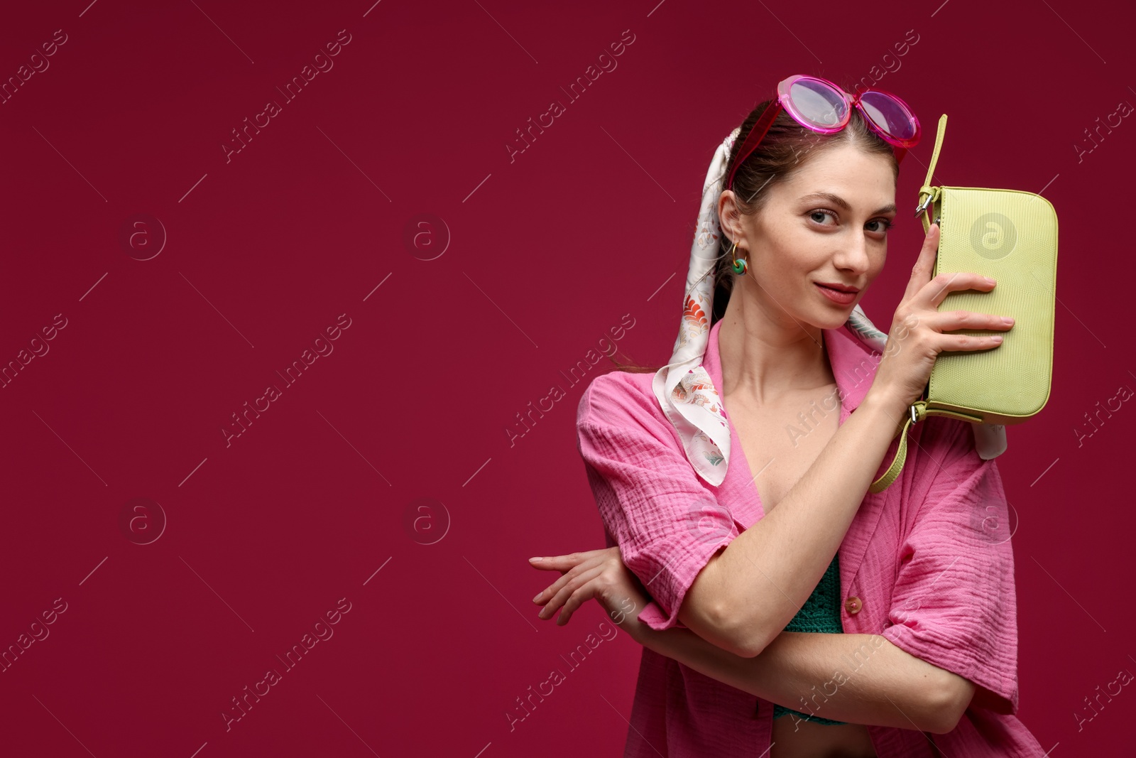 Fashionable portrait of beautiful woman in stylish outfit on dark red background. Space for text Photo of Fashionable portrait of beautiful woman in stylish outfit on dark red background. Space for text
