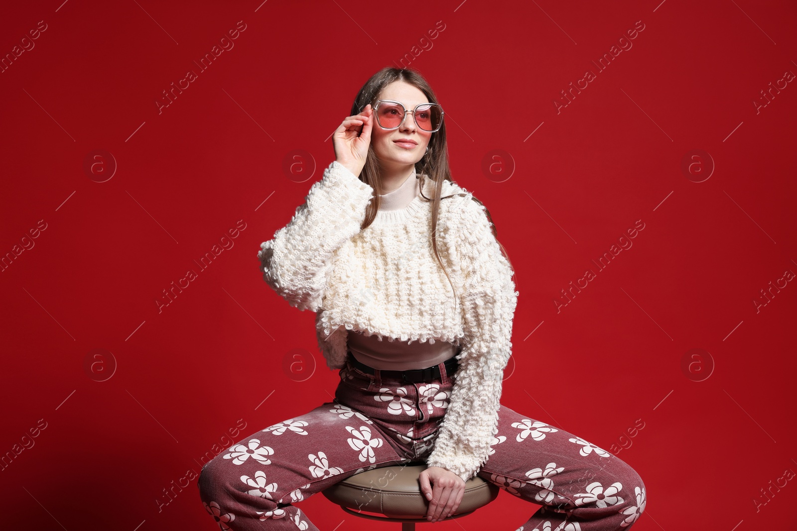 Fashionable portrait of beautiful woman in stylish outfit on red background Photo of Fashionable portrait of beautiful woman in stylish outfit on red background