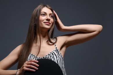 Photo of Fashionable portrait of beautiful woman in stylish outfit on grey background