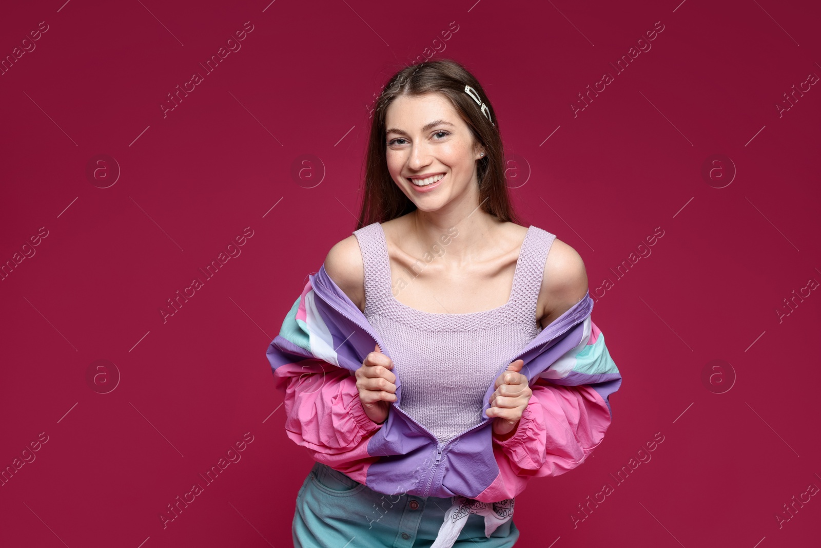 Fashionable portrait of beautiful woman in stylish outfit on crimson background Photo of Fashionable portrait of beautiful woman in stylish outfit on crimson background