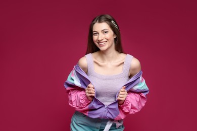 Photo of Fashionable portrait of beautiful woman in stylish outfit on crimson background