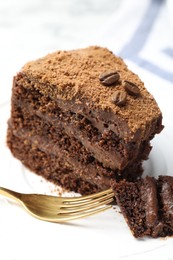Photo of Piece of delicious chocolate cake with coffee beans and fork on plate, closeup
