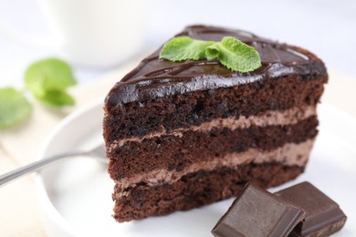 Photo of Piece of delicious cake, mint and chocolate on light table, closeup