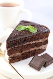 Photo of Piece of delicious cake, mint and chocolate on light table, closeup