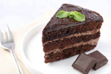 Photo of Piece of delicious cake, mint and chocolate on light table, closeup