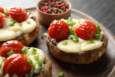 Photo of Tasty stuffed mushrooms served on black table, closeup