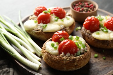 Photo of Tasty stuffed mushrooms served on black table, closeup