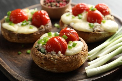 Photo of Tasty stuffed mushrooms served on black table, closeup