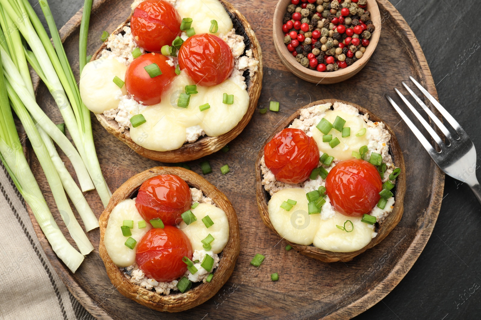 Tasty stuffed mushrooms served on black table, flat lay Photo of Tasty stuffed mushrooms served on black table, flat lay