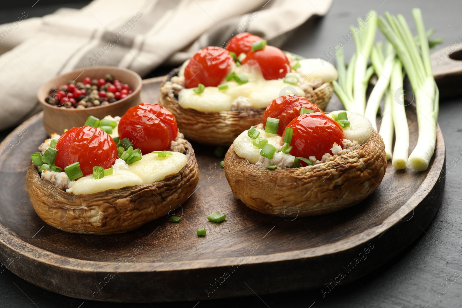 Tasty stuffed mushrooms served on black table, closeup Photo of Tasty stuffed mushrooms served on black table, closeup