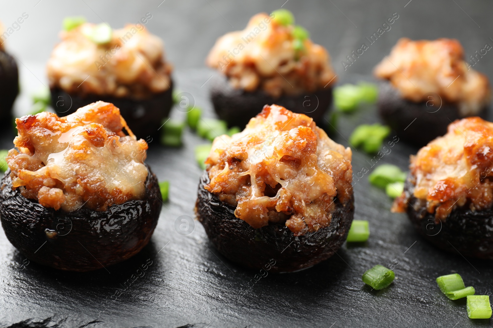 Tasty stuffed mushrooms served on black table, closeup Photo of Tasty stuffed mushrooms served on black table, closeup