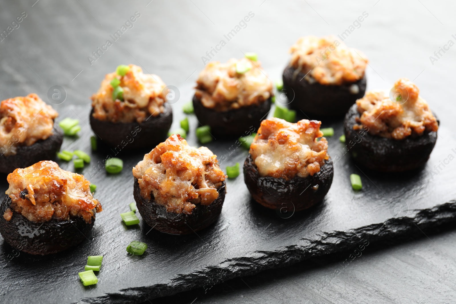 Tasty stuffed mushrooms served on black table, closeup Photo of Tasty stuffed mushrooms served on black table, closeup