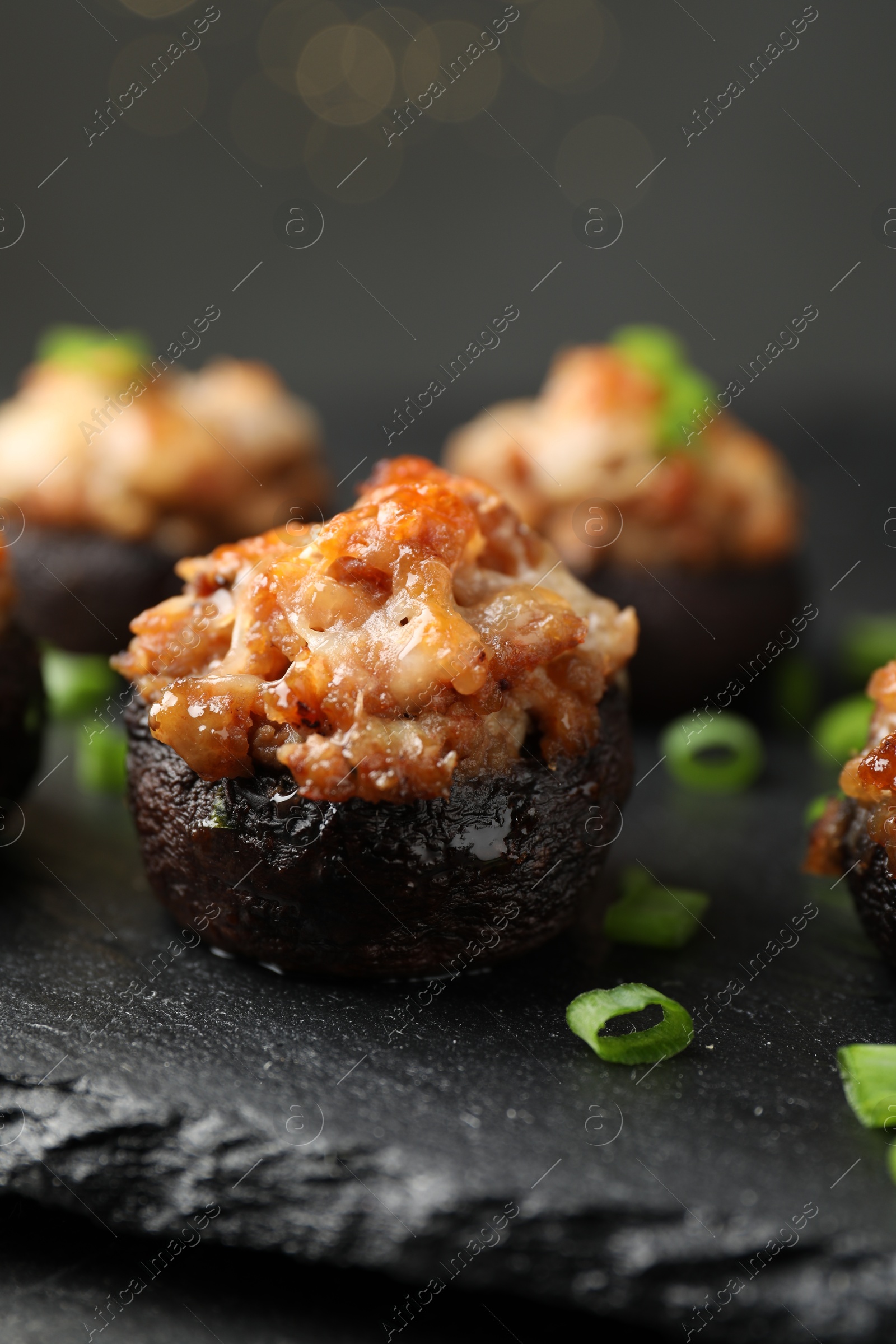 Tasty stuffed mushrooms served on black table against blurred background, closeup Photo of Tasty stuffed mushrooms served on black table against blurred background, closeup