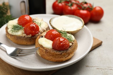 Photo of Tasty stuffed mushrooms served on light table, closeup