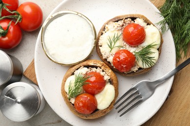 Photo of Tasty stuffed mushrooms served on light table, flat lay
