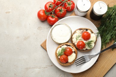 Photo of Tasty stuffed mushrooms served on light table, flat lay. Space for text