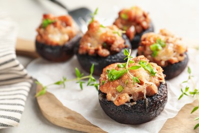 Photo of Tasty stuffed mushrooms served on light table, closeup