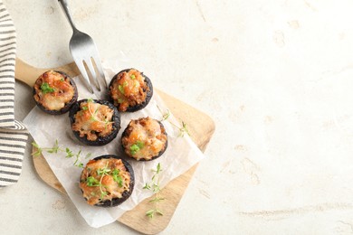 Photo of Tasty stuffed mushrooms served on light table, top view. Space for text