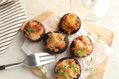 Photo of Tasty stuffed mushrooms served on light table, top view