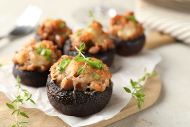 Photo of Tasty stuffed mushrooms served on light table, closeup