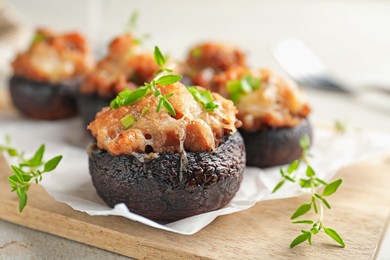 Photo of Tasty stuffed mushrooms served on light table, closeup