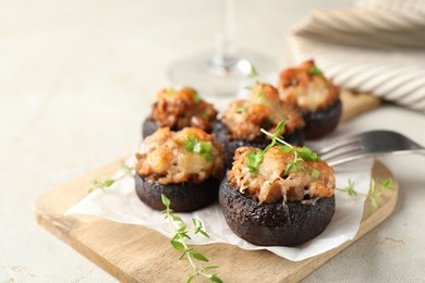 Photo of Tasty stuffed mushrooms served on light table, closeup