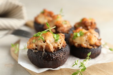 Photo of Tasty stuffed mushrooms served on light table, closeup