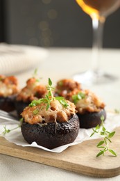 Photo of Tasty stuffed mushrooms served on light table against blurred background, closeup