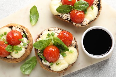Photo of Tasty stuffed mushrooms served on light table, top view