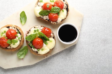 Photo of Tasty stuffed mushrooms served on light table, top view
