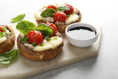 Photo of Tasty stuffed mushrooms served on light table, closeup