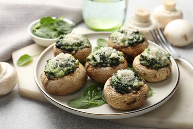 Photo of Tasty stuffed mushrooms served on light table, closeup