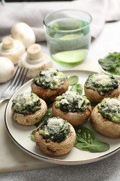 Photo of Tasty stuffed mushrooms served on light table, closeup