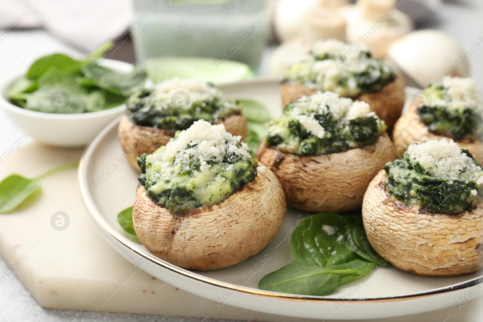 Tasty stuffed mushrooms served on light table, closeup Photo of Tasty stuffed mushrooms served on light table, closeup