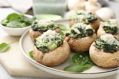 Photo of Tasty stuffed mushrooms served on light table, closeup