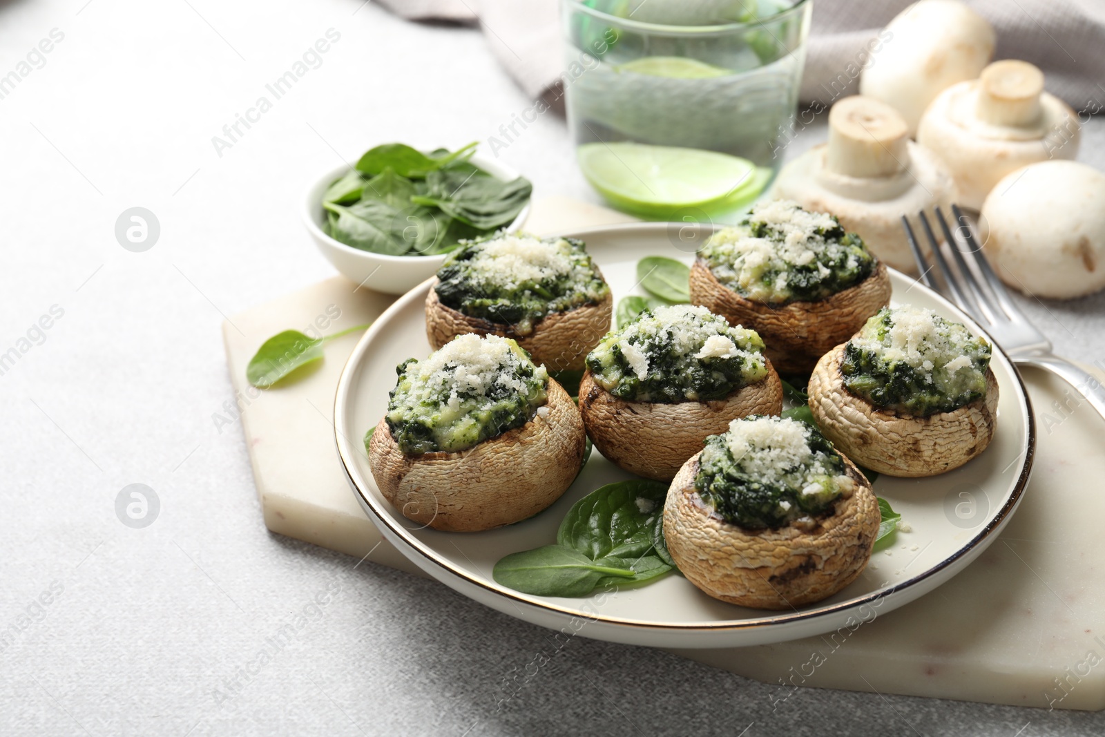 Tasty stuffed mushrooms served on light table, closeup Photo of Tasty stuffed mushrooms served on light table, closeup