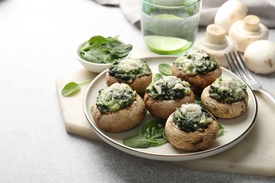 Photo of Tasty stuffed mushrooms served on light table, closeup
