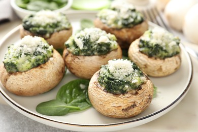 Photo of Tasty stuffed mushrooms served on light table, closeup