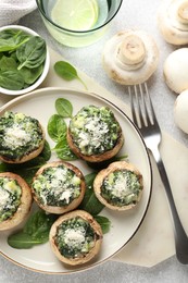 Photo of Tasty stuffed mushrooms served on light table, flat lay