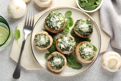 Photo of Tasty stuffed mushrooms served on light table, flat lay