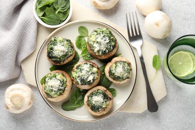 Photo of Tasty stuffed mushrooms served on light table, flat lay