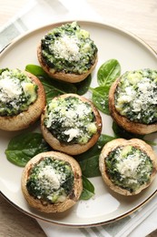 Photo of Tasty stuffed mushrooms served on light wooden table, top view