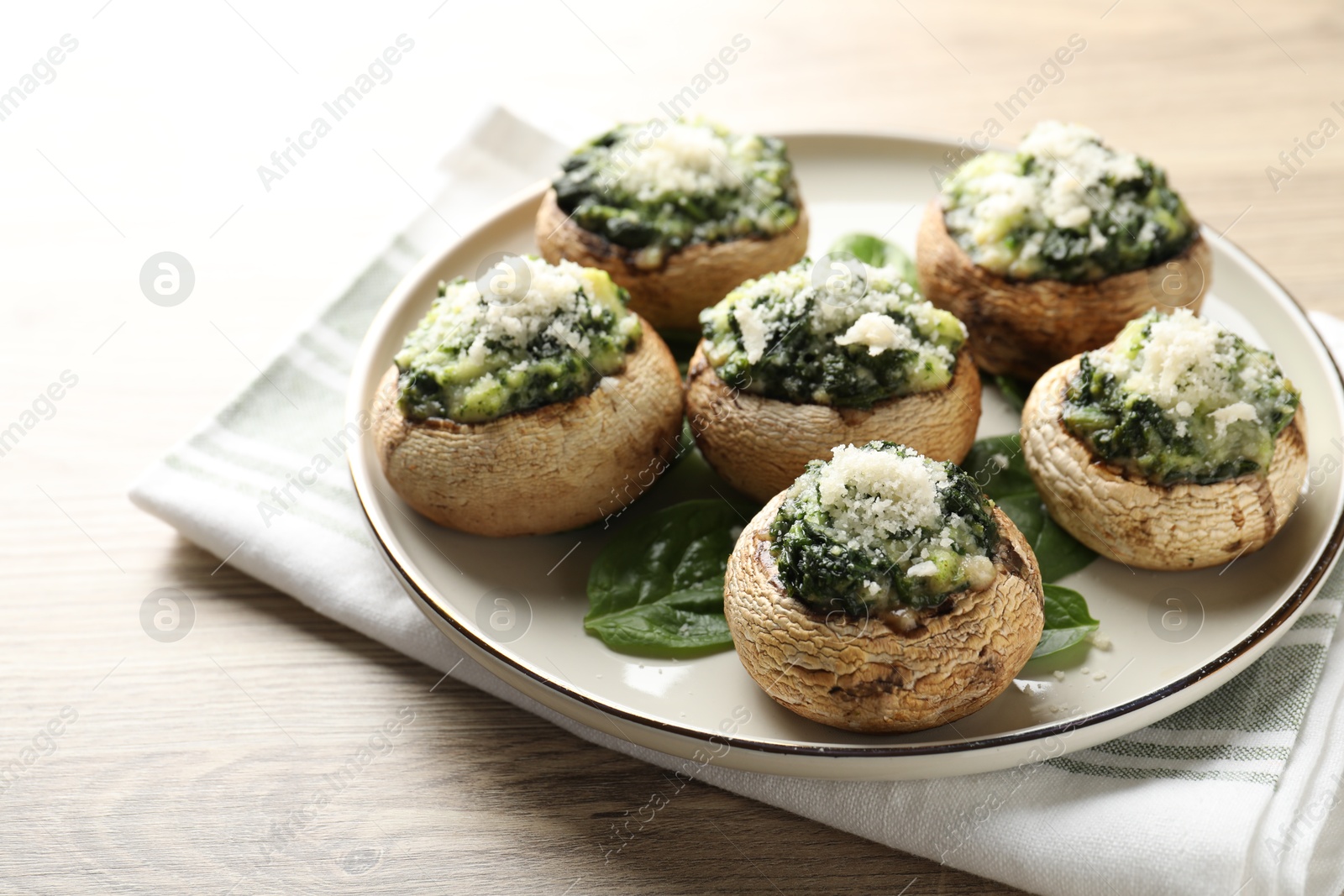 Tasty stuffed mushrooms served on light wooden table, closeup Photo of Tasty stuffed mushrooms served on light wooden table, closeup