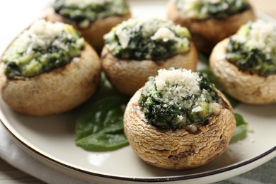 Photo of Tasty stuffed mushrooms served on table, closeup