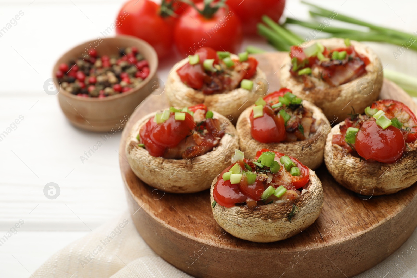 Photo of Tasty stuffed mushrooms served on white wooden table, closeup