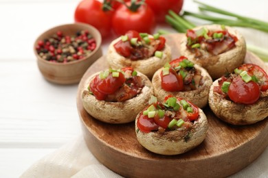 Photo of Tasty stuffed mushrooms served on white wooden table, closeup