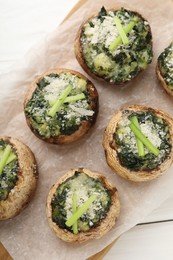 Photo of Tasty stuffed mushrooms served on white wooden table, top view
